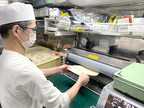 製麺機で生地をつくるスタッフ